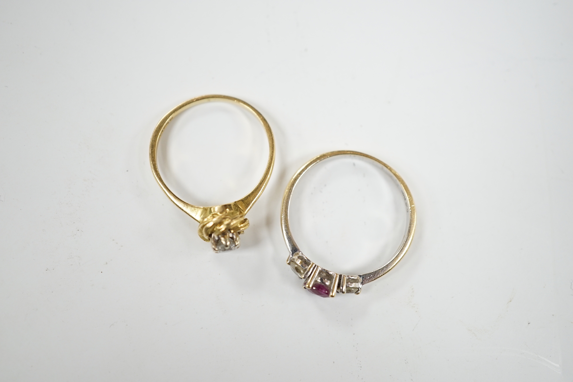 A modern 18ct white gold, ruby and diamond set three stone ring, size N/O and a 1970's 18ct gold and solitaire diamond set ring, size L, gross weight 5.3 grams.
